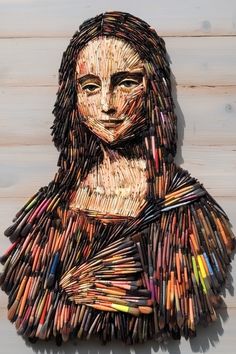 a woman made out of crayons on top of a wooden wall