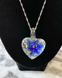 Large cobalt blue floral with gold glitter on white Murano style heart glass necklace with 2mm .925 sterling silver plated wave chain 22-23 cm chain drop length.  Please select chain length in menu.  If you want a chain of a different length not in the menu, please send me a message. Please include in the notes of your order. Necklace may look slightly different from photo. Nickel-free Blue Heart-shaped Jewelry, Blue Necklace With Round Heart Charm, Blue Necklace With Heart Charm, Blue Necklaces With Heart Charm And Round Shape, Nickel-free Murano Glass Jewelry For Gifts, Nickel-free Murano Glass Jewelry Gift, Blue Jewelry With Heart Charm For Gifting, Blue Nickel-free Heart Pendant Jewelry, Blue Heart Charm Jewelry For Gift