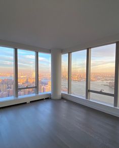 an empty room with large windows overlooking the city