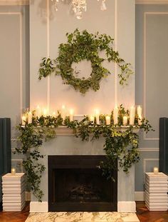 the fireplace is decorated with candles and greenery