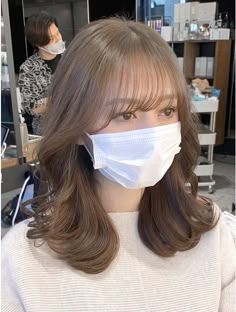 a woman wearing a face mask in a salon