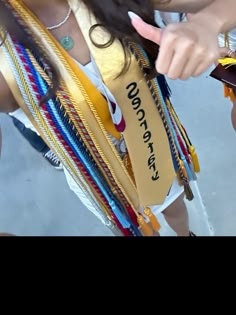 a woman is holding several bracelets and pointing at the tag on her belt that says victory