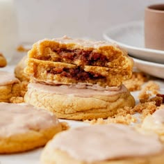 a close up of some cookies and doughnuts on a table with coffee in the background