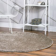 a white chair sitting on top of a hard wood floor next to a book shelf