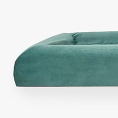 a large green couch sitting on top of a white floor