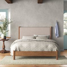 a bed sitting in a bedroom on top of a wooden floor next to a window