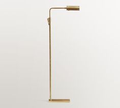 a gold colored floor lamp on a white background with the light turned on and off