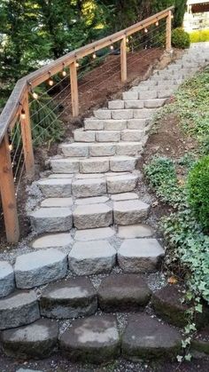 stone steps leading up to the top of a hill with string lights strung over them