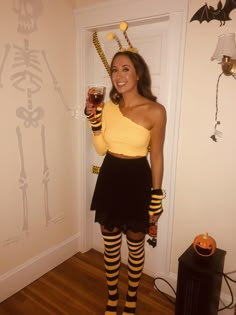 a woman dressed up as a skeleton holding a beer in her hand and wearing striped tights