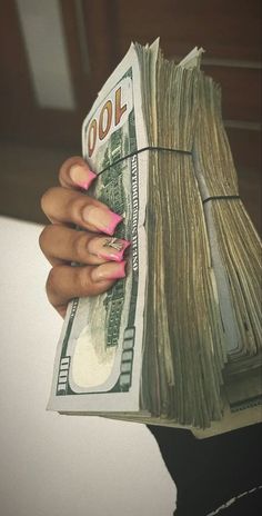 a woman's hand holding a stack of money with pink nails on it and the words cool written in black