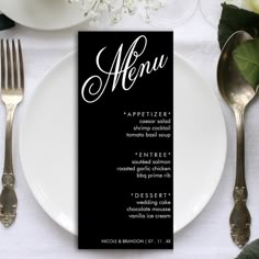 a table setting with silverware and black menu cards