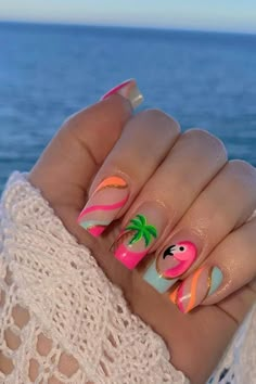 Embrace the tropical vibes with these almond-shaped summer vacation nails. A playful pink base is accented with a charming flamingo design, bringing a splash of vibrant personality. Swirling stripes of hot pink, pastel blue, and shining gold elegantly wrap across other nails, enhanced by a soothing palm tree motif that whispers the promise of relaxing beach days. The combination of pastels and lively hues make for a perfect summertime accessory. Beachy and chic! 🌴🦩  // Photo Credit: Instagram @nailsbykatyrose