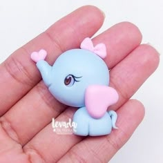 a small blue toy elephant sitting on top of a person's hand