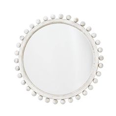 a white round mirror with beads on the rim