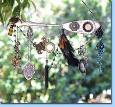 an assortment of jewelry hanging from a tree branch