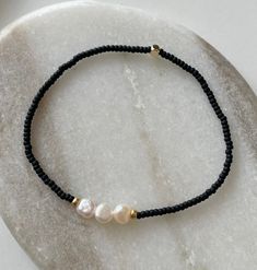 ♡ Florence ♡ Bracelet - Statue is not included, this listing is for the bracelet only - Very dainty and elegant beaded bracelet with Freshwater pearls. Please bear in mind that all Freshwater Pearls have unique shapes and sizes, no two pearls look the same. ♥ Small matt black beads ♥Three gold plated beads ♥ three small Freshwater pearls ♥ Stretchy cord so you can easily put it on and take it off ↠ All my jewellery is handmade by me in the U.K ↠ I will ship next day where possible except for wee Elegant Heishi Bead Bracelets With Tiny Beads, Handmade Elegant Heishi Beads Bracelets, Minimalist Beaded Stretch Bracelet, Adjustable Black Pearl Beaded Bracelets, Handmade Minimalist Pearl Beaded Bracelets, Elegant Round Beaded Bracelets With Letter Beads, Everyday Beaded Pearl Bracelet, Elegant Beaded Bracelets With Letter Beads For Jewelry Making, Black Beaded Pearl Bracelets