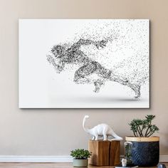 an animal statue on top of a wooden table in front of a wall mounted art piece