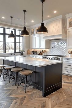 a large kitchen with an island in the middle and stools at the counter top