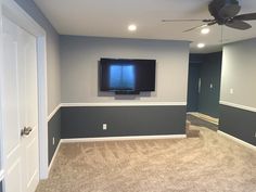 an empty room with a flat screen tv mounted on the wall and carpeted floor