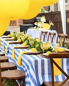 a table set up with yellow and blue striped linens for a party or celebration