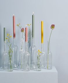 several vases with flowers and candles in them