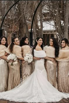 a group of women standing next to each other in front of some trees and snow