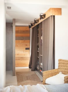 a bed room with a neatly made bed next to a wooden wall and open curtains