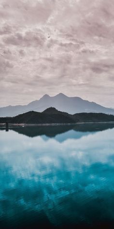 the sky is reflected in the water and mountains are in the backgrouund