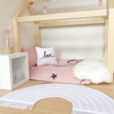 a dollhouse bed with pink and white decor