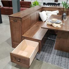 a wooden bench with drawers underneath it in a room filled with tables and couches