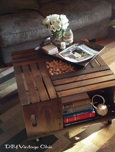 a coffee table with some books on it and flowers in a vase sitting on top