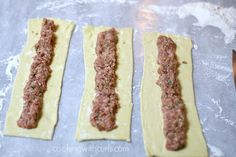 three uncooked pizza doughs sitting on top of a baking sheet