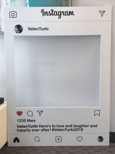 an instagram photo frame with hearts on the front and bottom, sitting next to a refrigerator