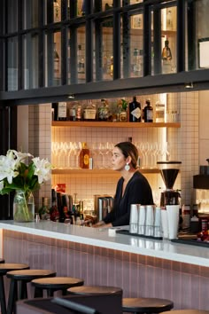 a woman sitting at a bar behind a counter