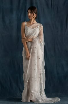 This set features a soft grey pre-stitched saree includes a pleated wrap skirt in georgette with an attached silk organza drape embroidered with silk thread, silver dabka, and glass beads. It comes... Farewell Saree, Farewell Sarees, Indian Fits, Sari Design, Grey Saree, Modern Saree