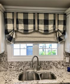 a kitchen window with black and white checkered valance over the sink, next to a granite countertop