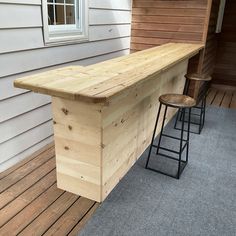 an outdoor bar made out of pallet wood with two stools next to it