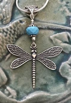 Antique silver dragonfly pendant necklace with chain and your choice of either turquoise or lapis lazuli gemstone.Are you a lover of all things dragonfly? Dragonfly is the bringer of visions of power. Flighty and carefree dragonflies symbolize whirlwind, swiftness and activity. They are also thought to bring good luck.This beautiful dragonfly pendant will definitely bring joy to your life. It’s very lightweight and unique. The sterling silver plated dragonfly is hand cast in the United States. I Nickel-free Blue Dragonfly Jewelry, Silver Wire Wrapped Charm Necklace As Gift, Bohemian Butterfly Charm Jewelry For Gift, Dainty Sterling Silver Dragonfly Jewelry, Handmade Dragonfly Necklace For Gifting, Handmade Dragonfly Necklace For Gift, Handmade Bohemian Dragonfly Necklace, Bohemian Handmade Dragonfly Necklace, Hypoallergenic Sterling Silver Dragonfly Jewelry