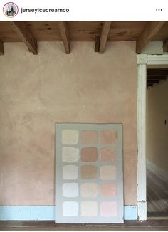 an empty room with pink walls and wooden beams on the ceiling, in front of a white door