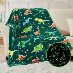 a green blanket with dinosaurs on it