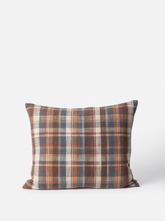 a brown and blue plaid pillow on a white background