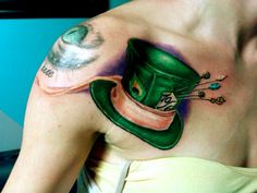 a woman with a green top hat tattoo on her shoulder