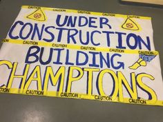 a sign that says under construction, building championships and cautions on the side of a wall