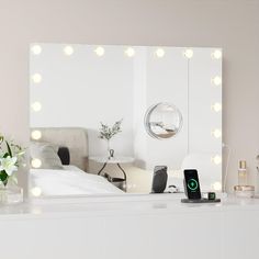 a white dresser topped with a mirror and lights