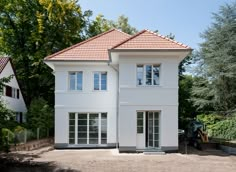 a large white two story house with red tiled roof