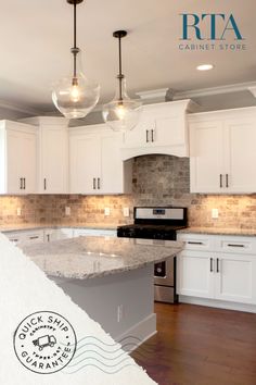 a kitchen with white cabinets and marble counter tops, an island in the middle is surrounded by hanging lights