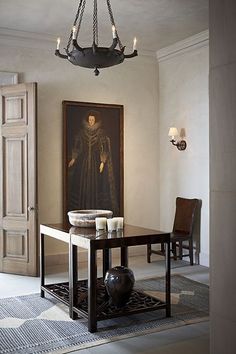 an image of a dining room with a painting on the wall and chandelier