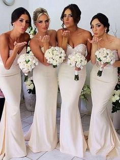 the bridesmaids are all dressed in white gowns and holding their bouquets