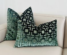 two pillows sitting on top of a white couch