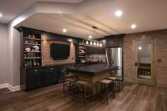 a large kitchen with wooden floors and black cabinets